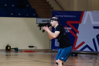 Игрок LASERWAR в движении, нацелившись из укрытия.